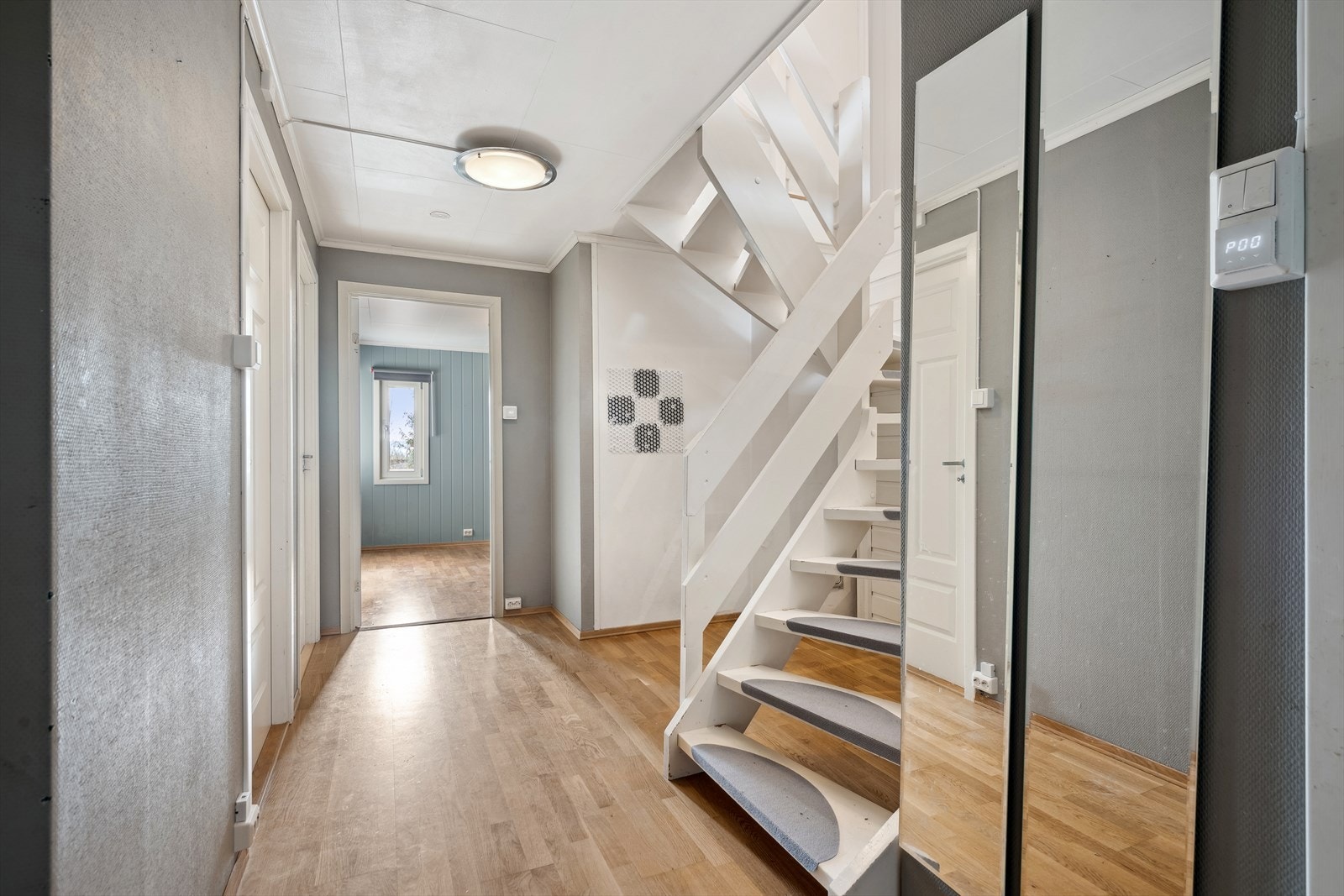 Trappegangen i kjelleren har gjennomgående laminatgulv og mulighet for lagringsplass under trappen. Galleribilde