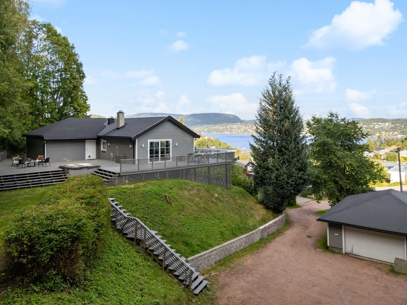 Tomt er opparbeidet med plen, vei og parkeringsareal. Galleribilde