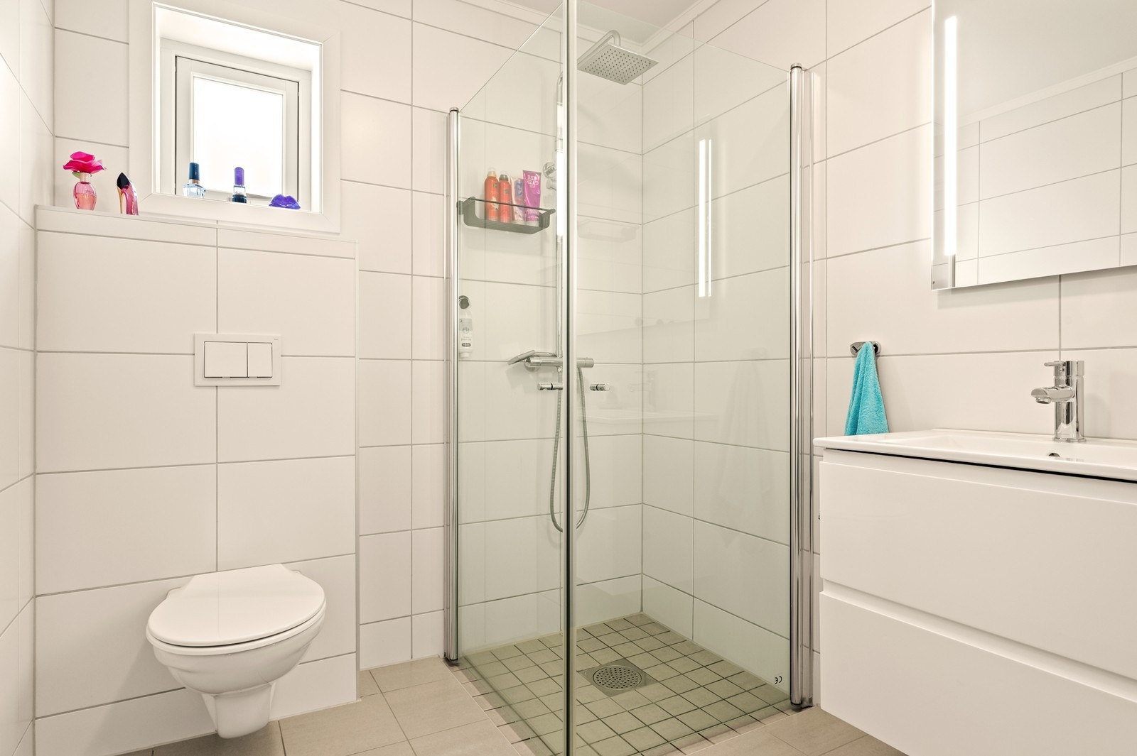 Badet har dusjhjørne med glassvegger og vegghengt toalett. Galleribilde