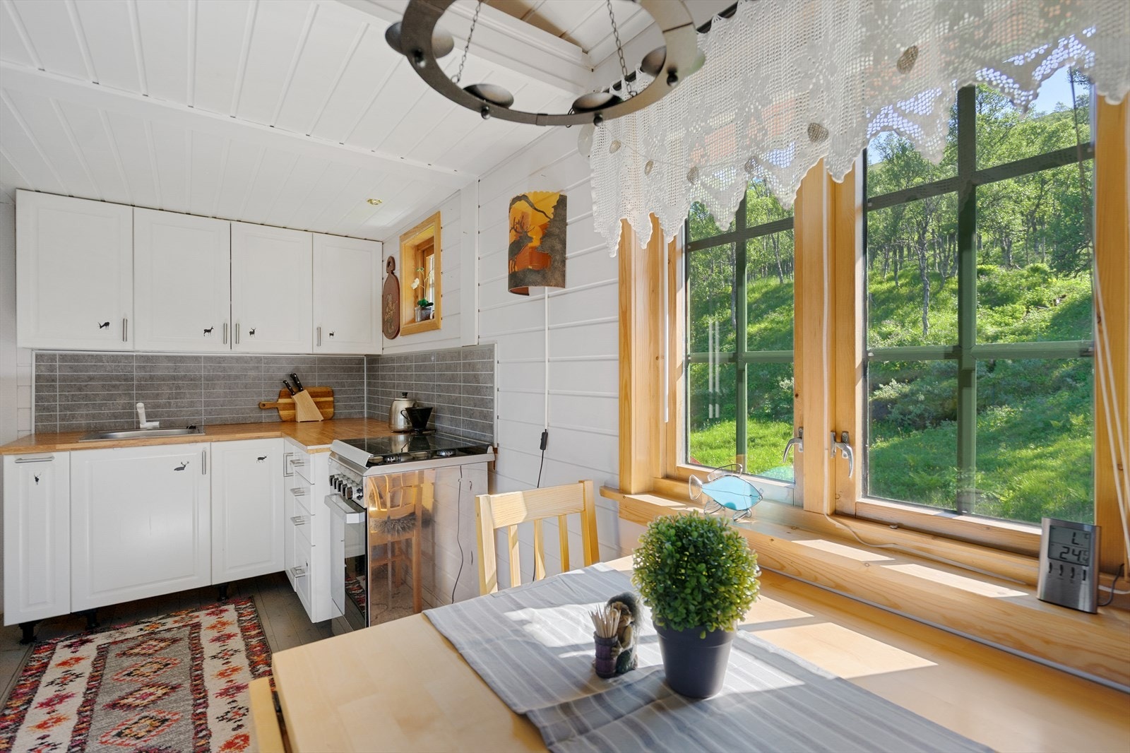 Kjøkken med plass til spisebord, utsikt mot grønne og frodige omgivelser Galleribilde