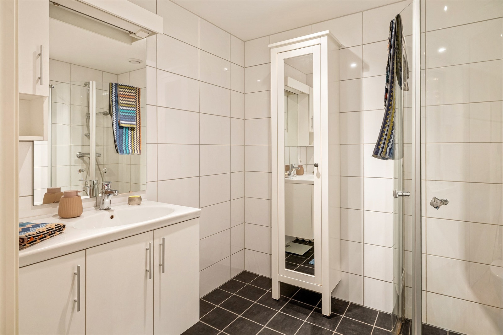 Pen vegghengt innredning og høyskap som gir god oppbevaring av både håndklær og toalettsaker Galleribilde