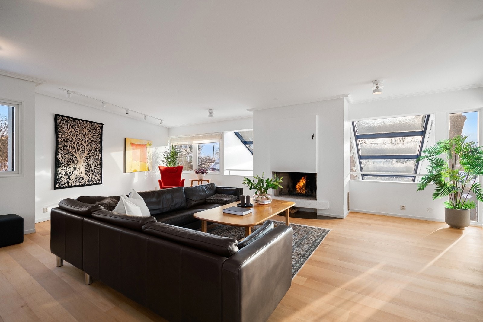 Stuen ligger på øvre plan, med åpning ned mot spisestuen og utsikt gjennom glasstaket mot omgivelsene utenfor.