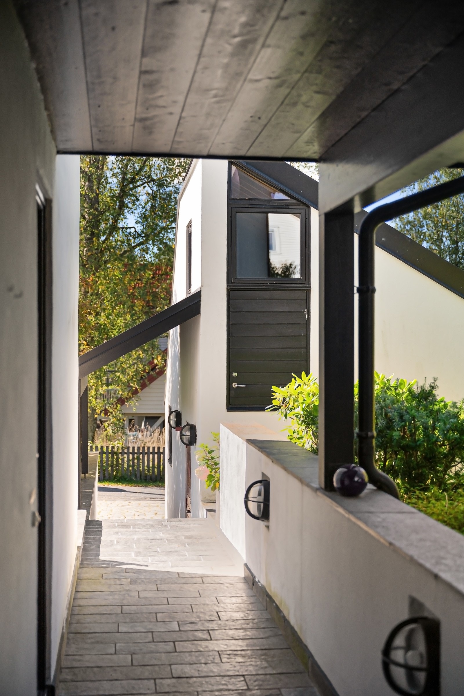 En flislagt terrengtrapp og gangvei med varmekabler leder fra gårdsplassen opp til boligen.