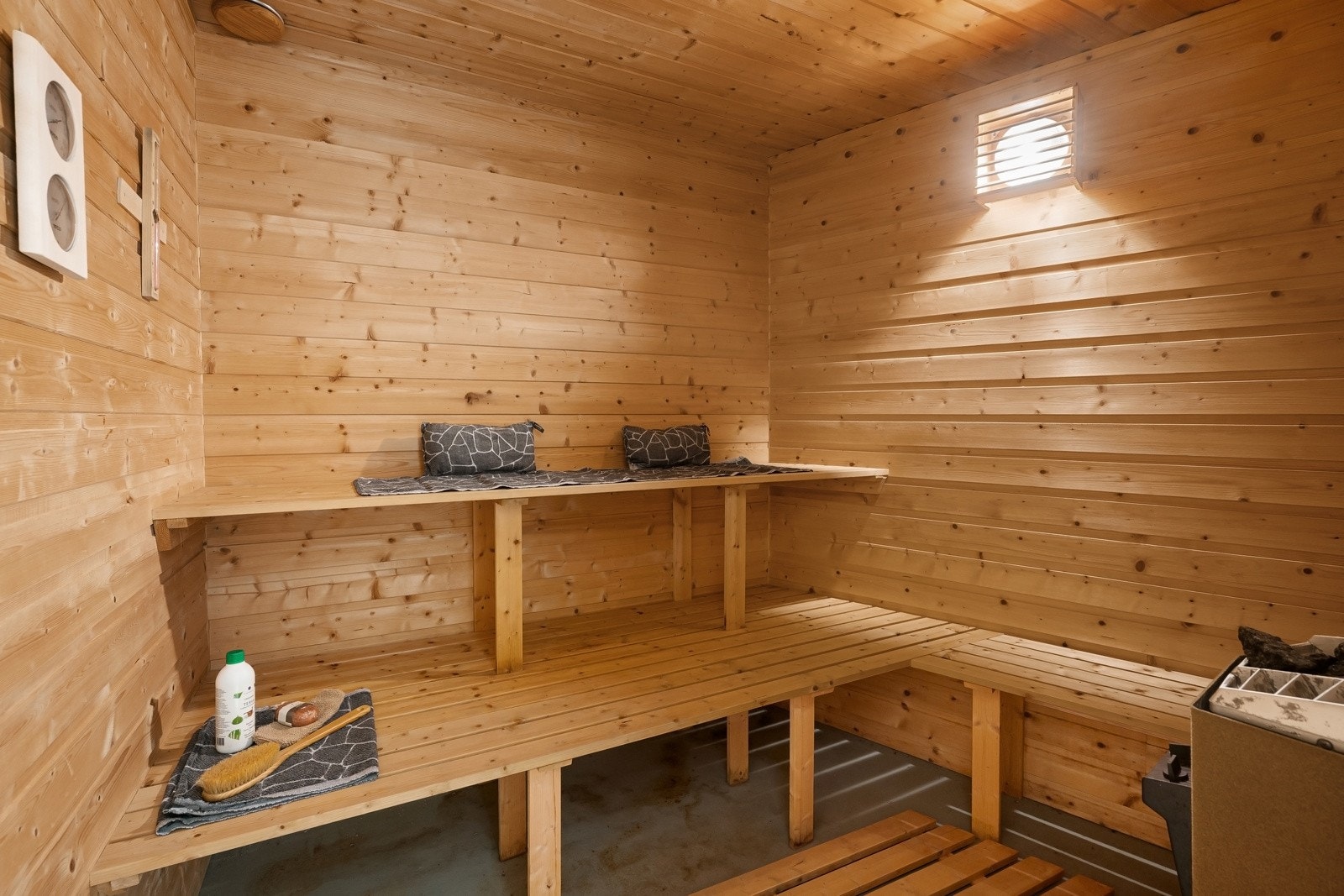 Badstuen har gulv i betong med tremmer i tre i gangsonen samt panel på vegg- og himlingsflater