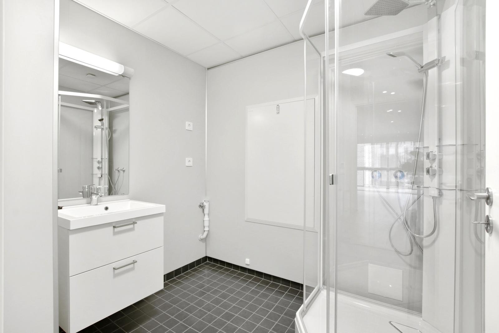 Bad/vaskerom med dusjkabinett og opplegg for vaskemaskin Galleribilde