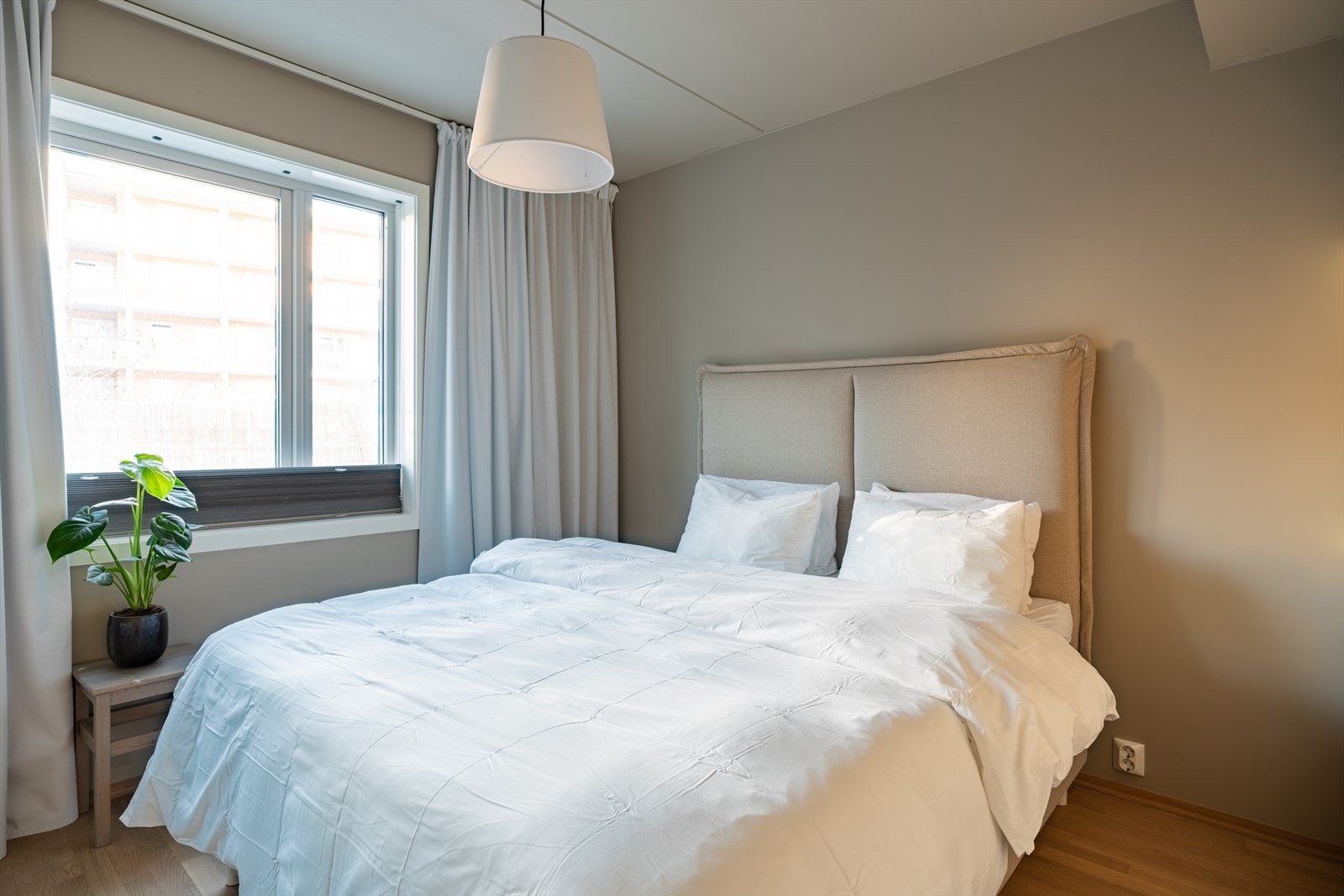 Romslig hovedsoverom med vindu mot indre gårdsrom. Galleribilde