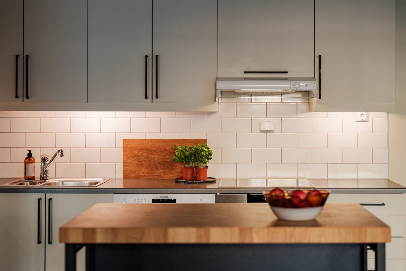 Det er lagt klassiske fliser på vegg mellom benk og overskap. Galleribilde