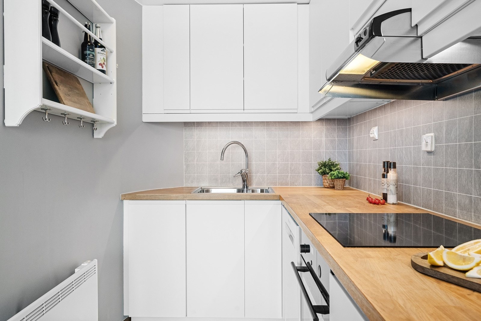 Flott vinklet kjøkken med hvite fronter og godt med skap- og benkeplass. Galleribilde