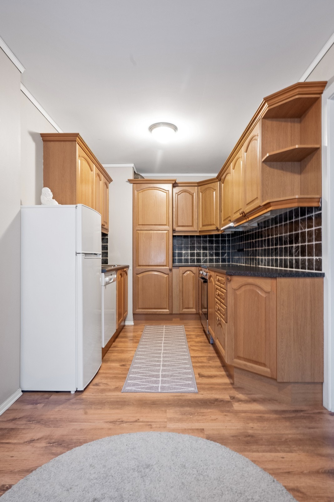 Plass til kjøleskap og oppvaskmaskin integrerer viktige hvitevarer i kjøkkeninnredningen. Galleribilde