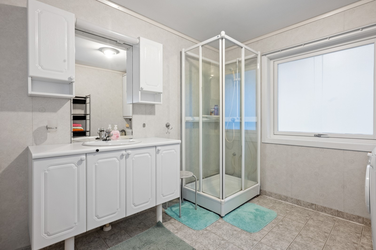 Flislagt gulv og våtromstapet på vegger gir et praktisk og lettstelt bad. Galleribilde