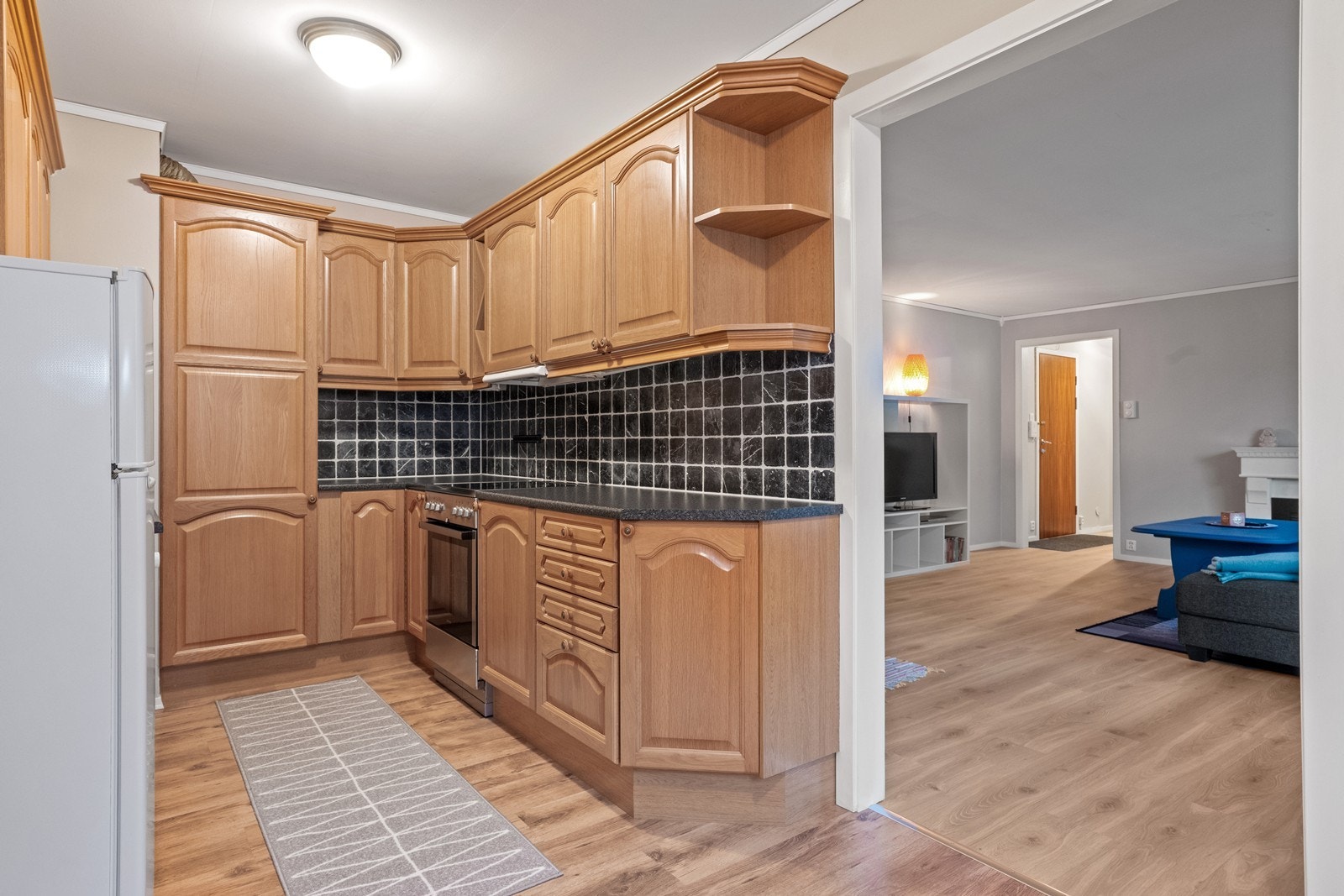 Direkte forbindelse til stuen gir en praktisk overgang fra kjøkkenet. Galleribilde