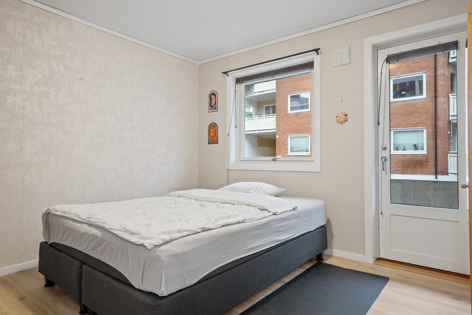 Laminatgulv gir et slitesterkt underlag i soverommet, som har utgang til en smal luftebalkong. Galleribilde