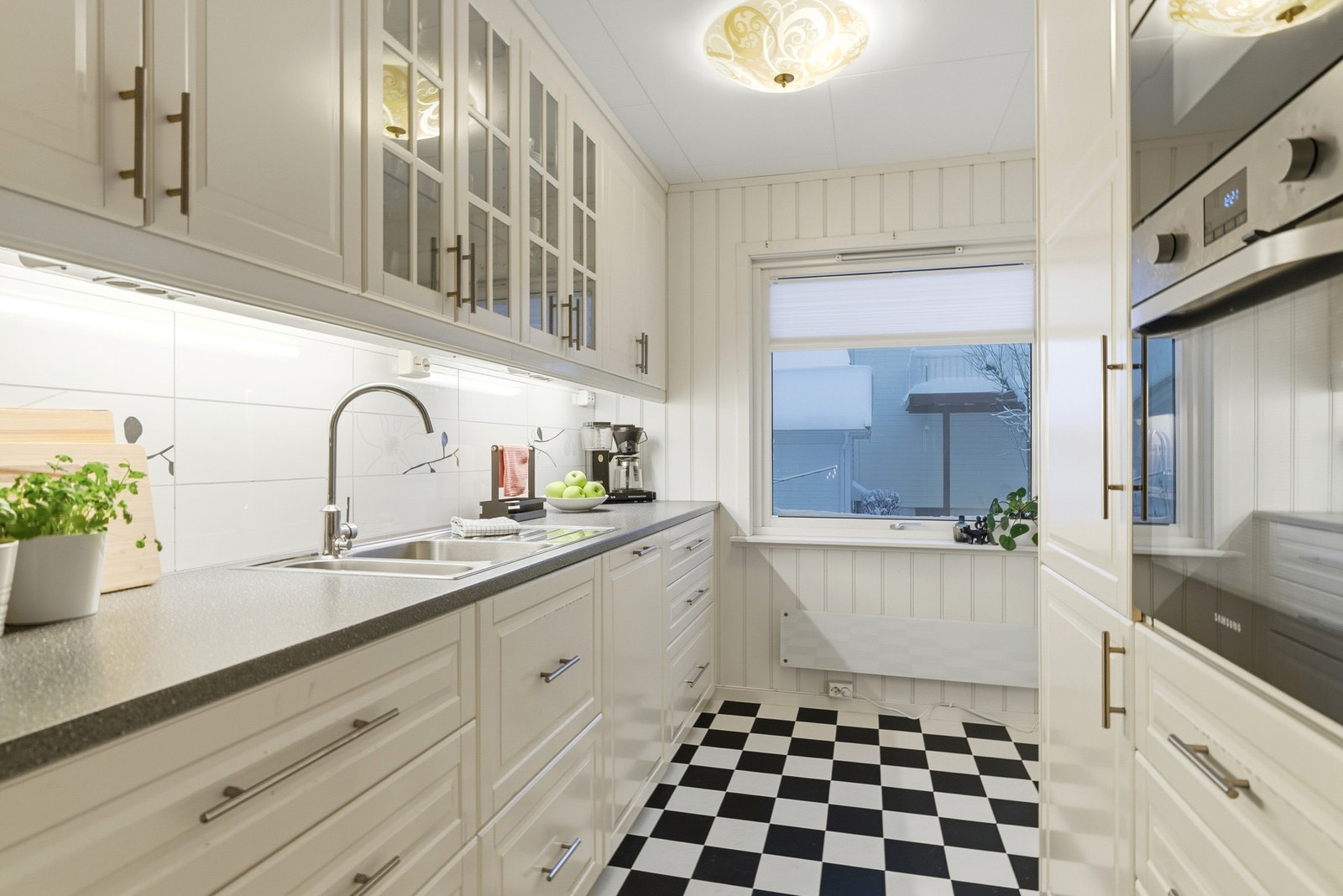 Kjøkkenet har lys innredning med profilerte fronter og integrerte hvitevarer. Galleribilde