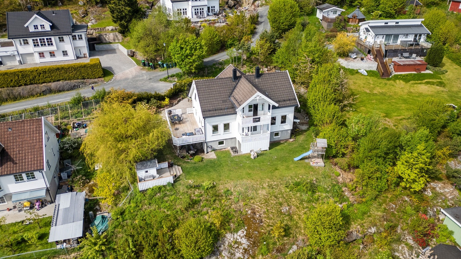 Tomten på 1007 kvm er pent opparbeidet med gressplen, gruslagt gårdsplass, trær og prydbusker. Galleribilde