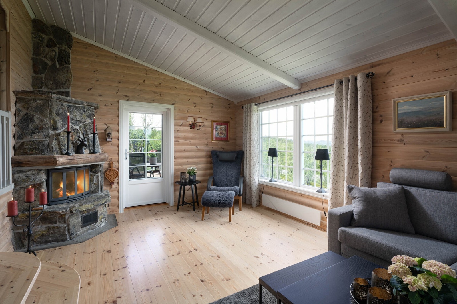 Stue med peis og utgang til delvis overbrygd terrasse Galleribilde