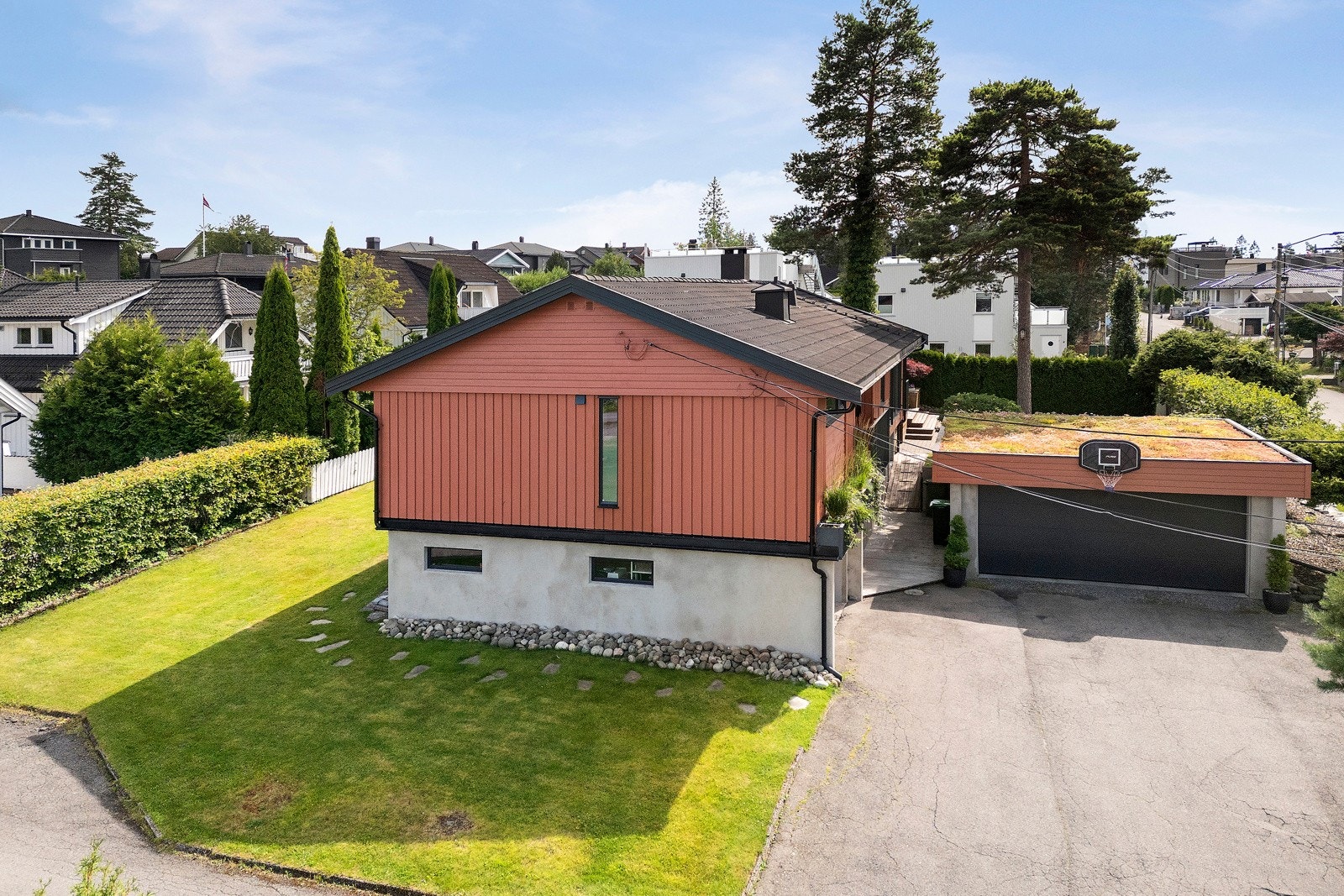 Foran huset er det asfaltert gårdsplass og innkjøring til dobbelgarasje og enkelgarasje. Galleribilde