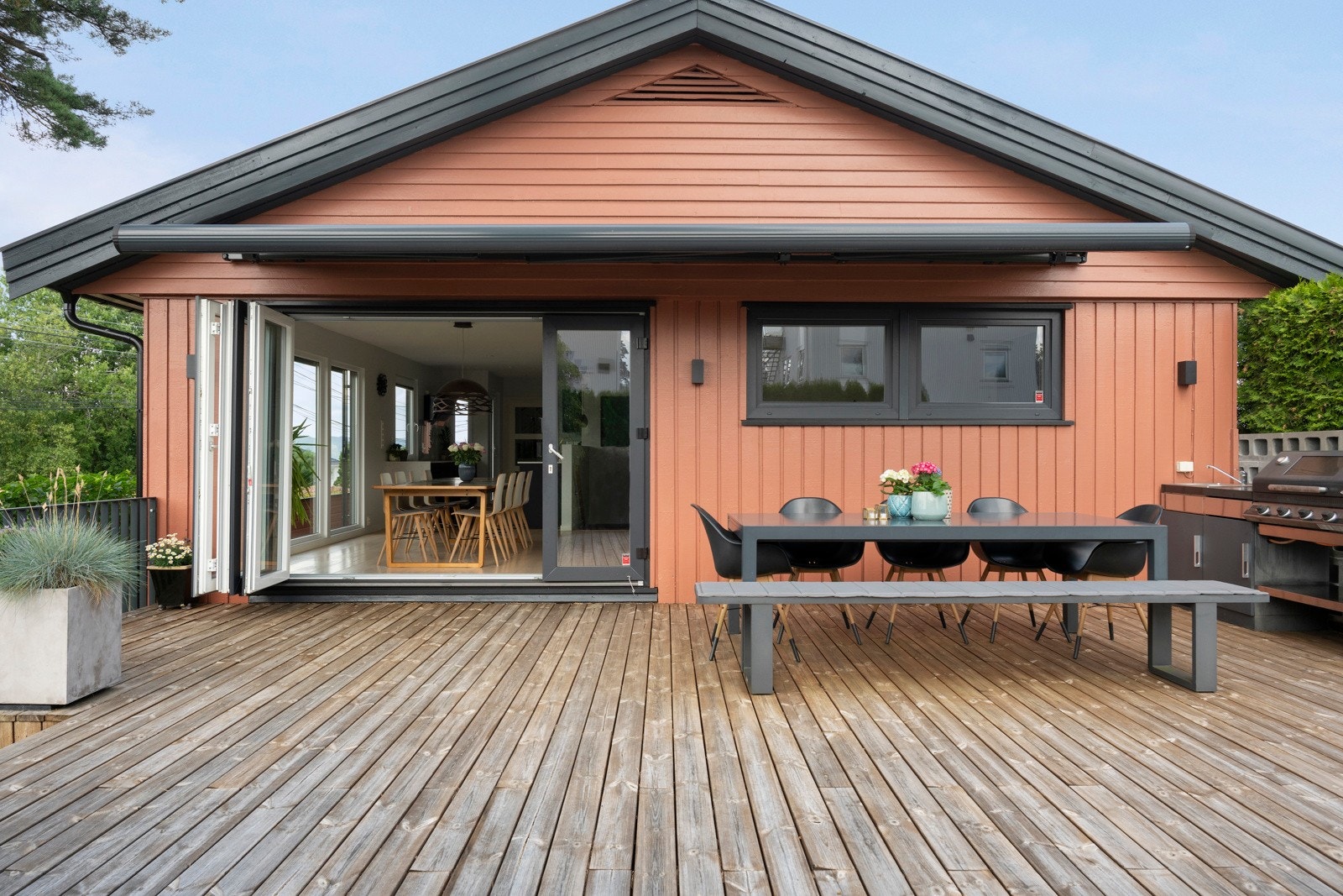 På terrassen er det etablert et moderne og funksjonelt utekjøkken, og den store foldedøren knytter innerom og uterom fint sammen. Galleribilde