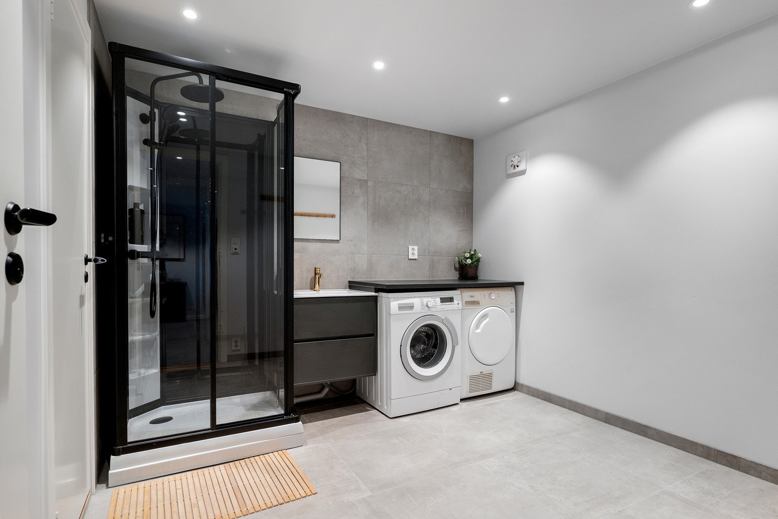 Romslig vaskerom med innredning, opplegg for vaskemaskin og tørketrommel, samt dusjløsning - fint oppusset i 2025. Galleribilde