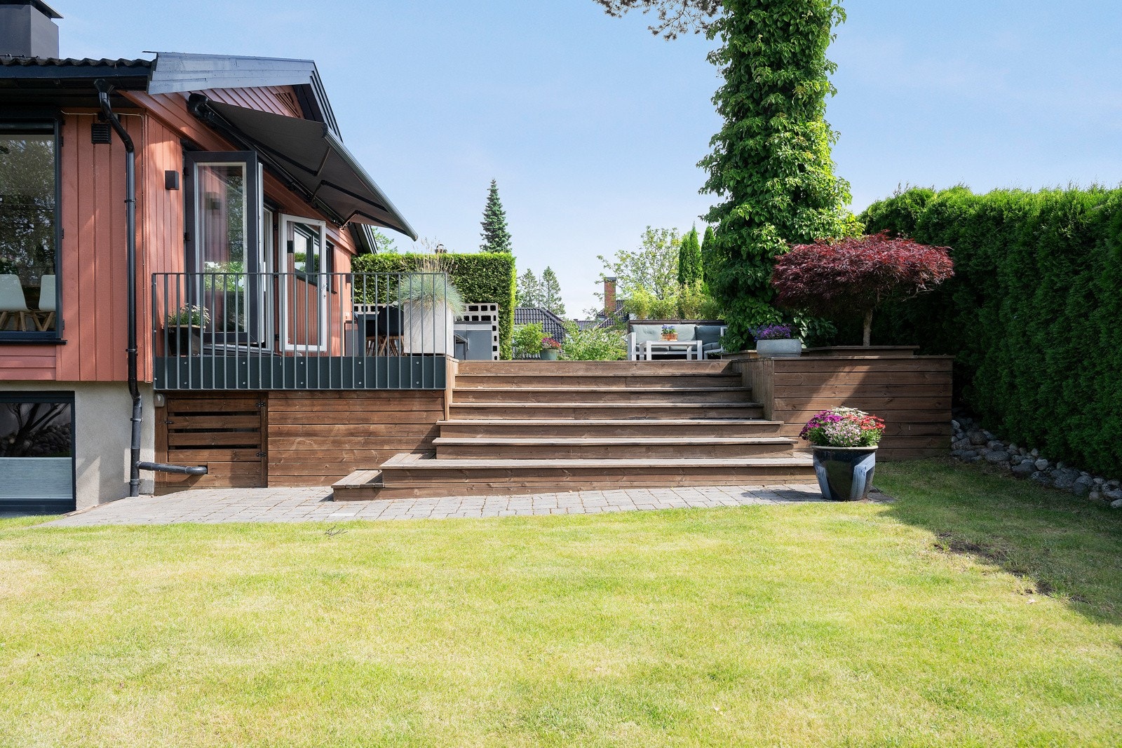 Fra terrassen er det trapp ned til en flat og fin hage som inviterer til lek og moro. Galleribilde