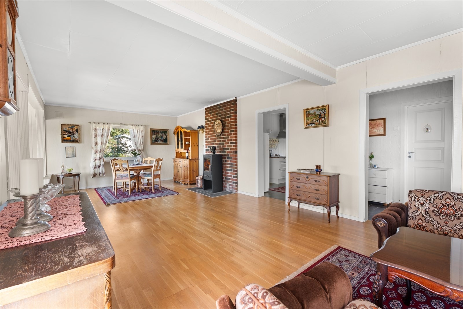 Stuen er romslig og innbydende, med god plass til både sofagruppe og spisebord. Den naturlige utformingen gir en tydelig soneinndeling mellom spiseplassen og stuen. Galleribilde