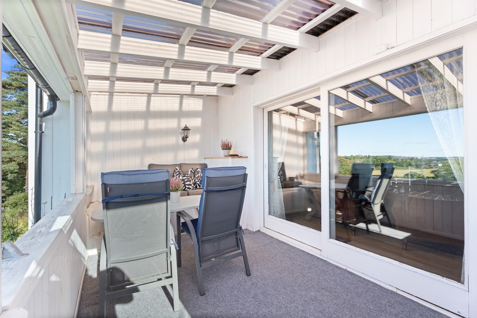 Utgang til en sørvestvendt innglasset terrasse på ca. 10 m², som oppleves som en forlengelse av stuen. Galleribilde