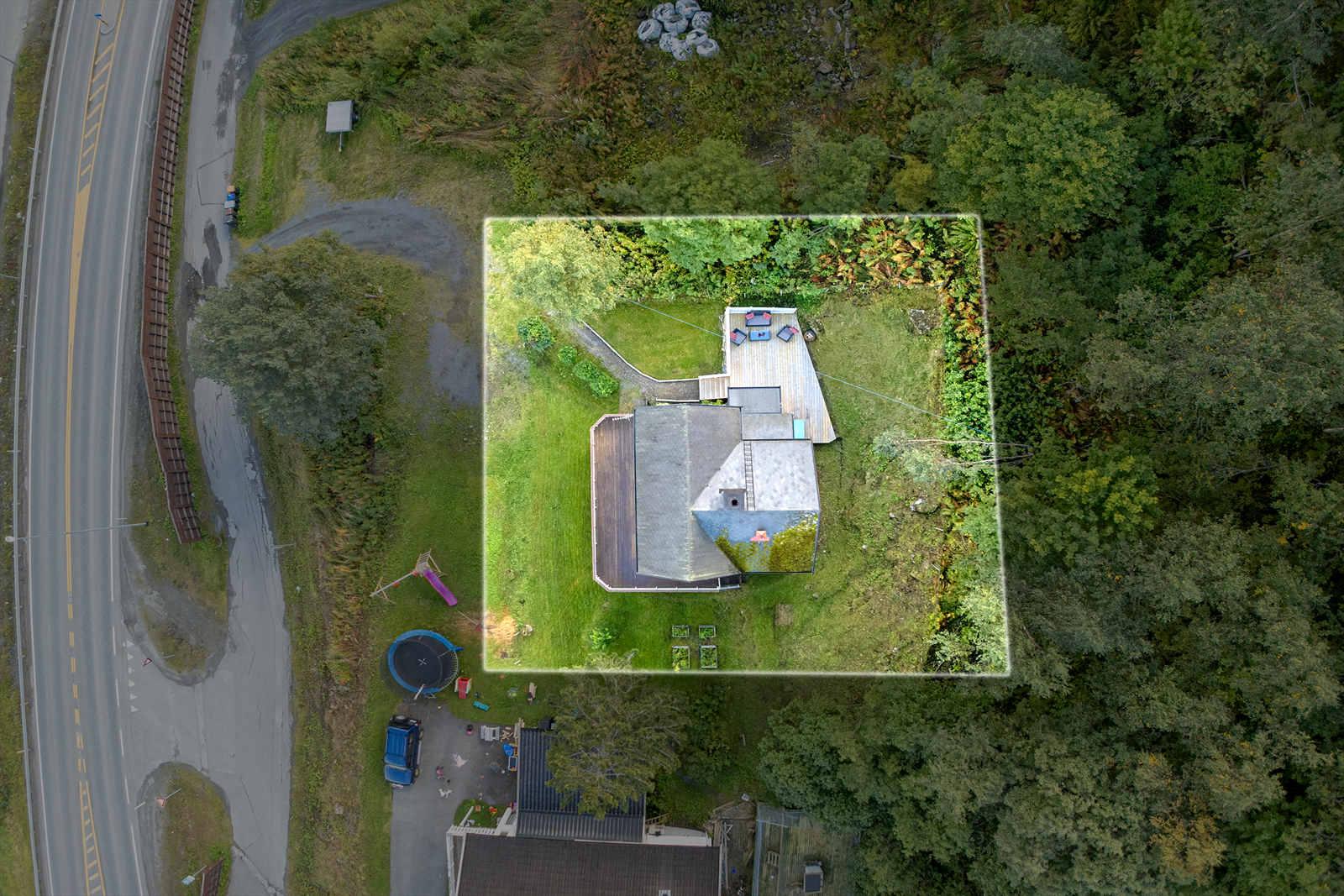 Eiendommen disponerer en romslig tomt med solrike uteplasser og gode muligheter for lek og aktiviteter Galleribilde