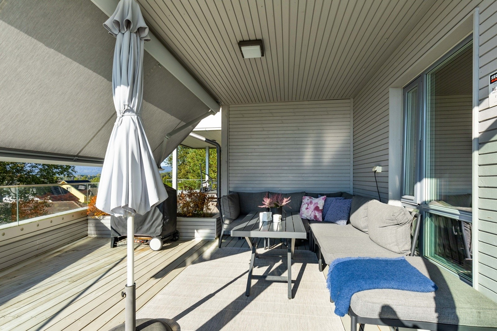 Overbygd uteplass med markise som inviterer til avslapning året rundt. Galleribilde
