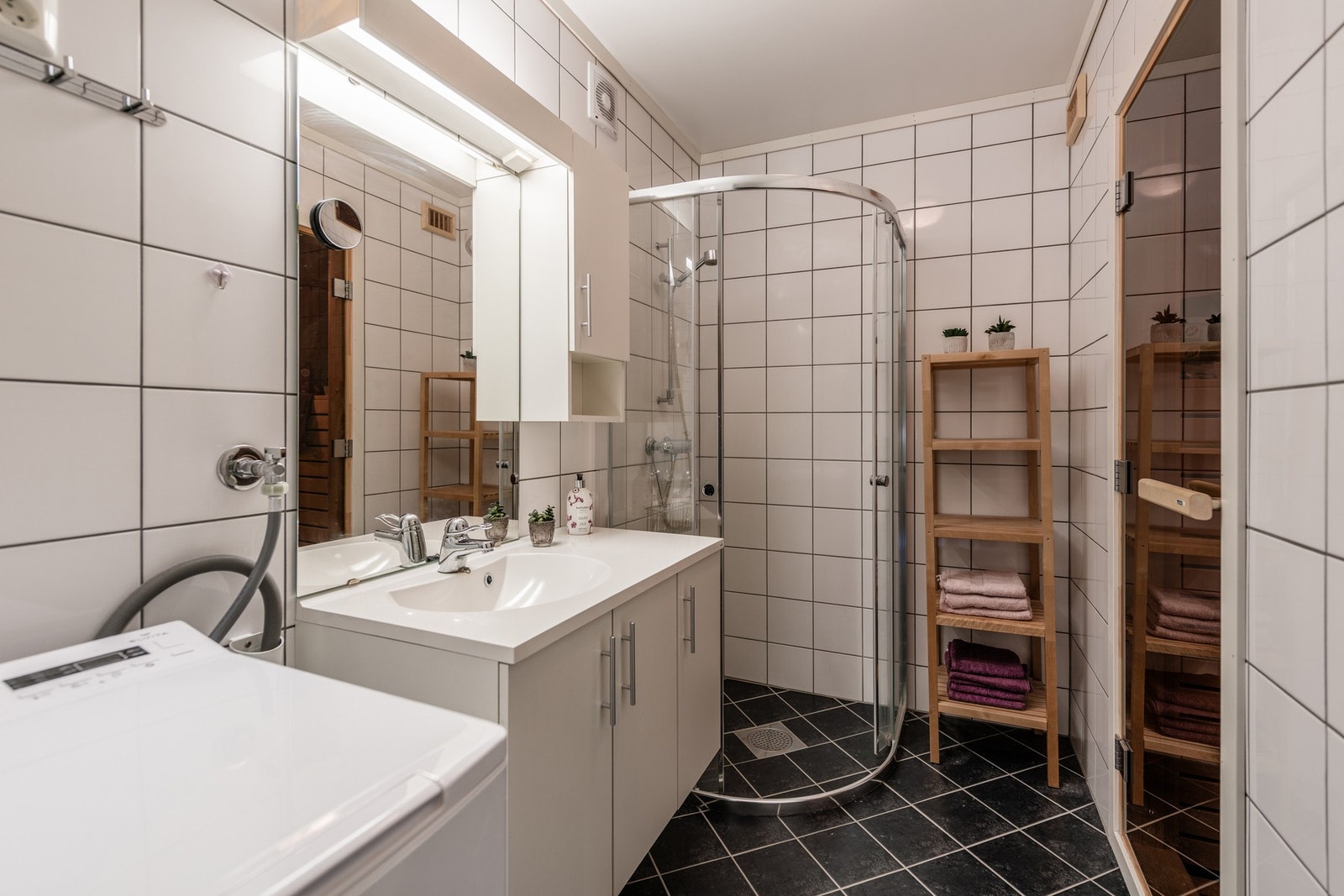 Bad med servant, dusjvegger og opplegg for vaskemaskin, samt tilgang til badstuen - det perfekte sted for avkobling etter en lang dag ute! Galleribilde