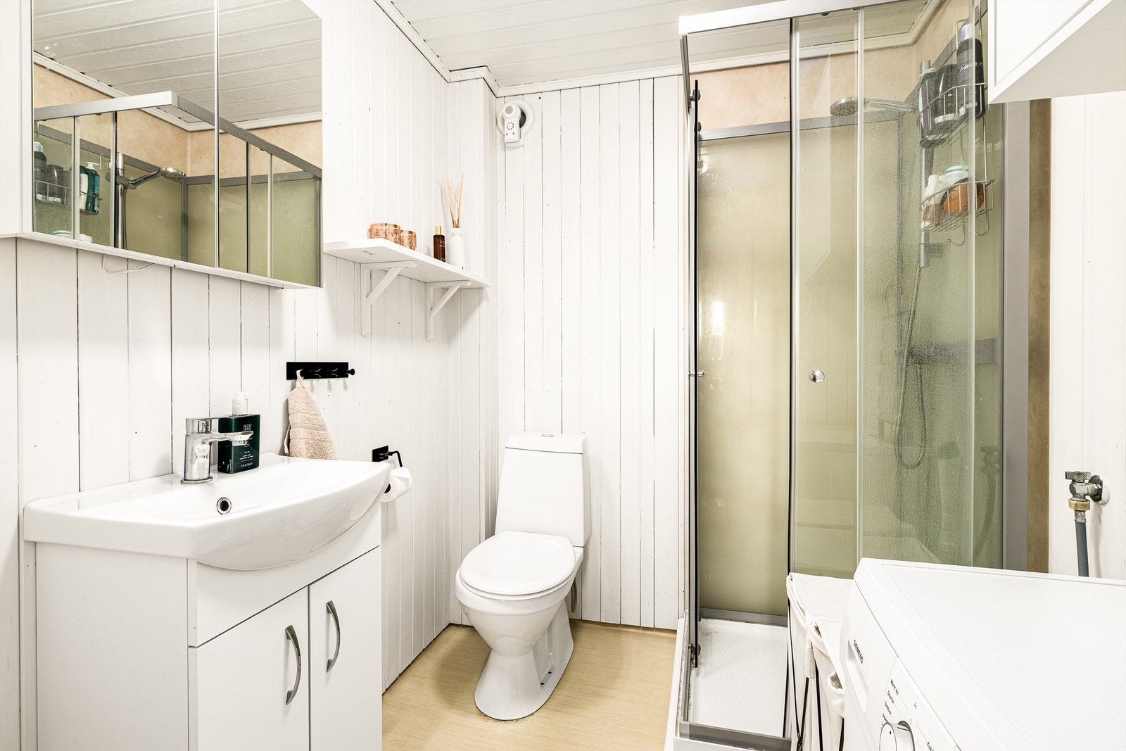 Bad hybel har servant i innredning, dusjkabinett og gulvsatt toalett Galleribilde