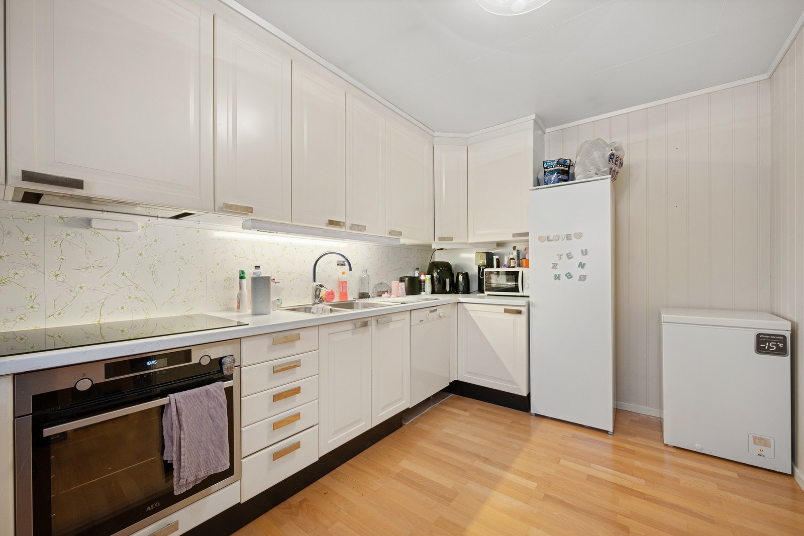 Integrert stekeovn med nedfelt platetopp, ellers frittstående hvitevarer Galleribilde