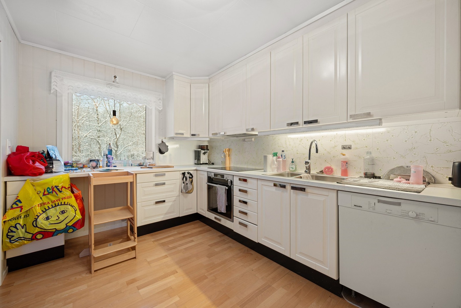 Kjøkkenet har nyere innredning med hvitmalte fronter og takhøye overskap Galleribilde