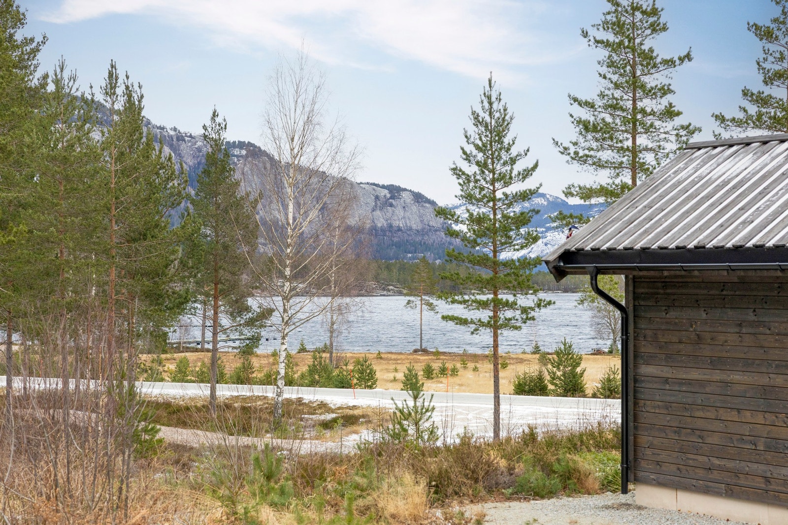 Utearealer som strekker seg langs fasaden, med flott utsyn mot Nisser og nærliggende naturområder. Galleribilde