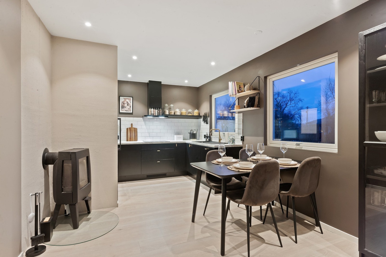 Fra stue mot kjøkken er vedfyring fint plassert sentralt i rommet. Galleribilde