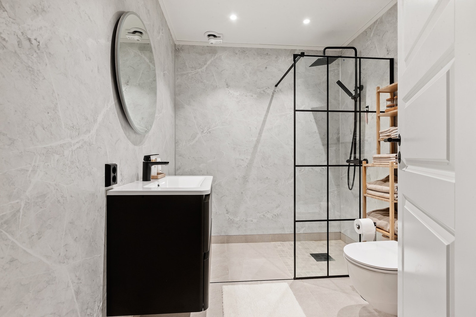 Lekkert bad med vegghengt toalett, sorte detaljer på innredninger og behagelig varme i gulv. Galleribilde