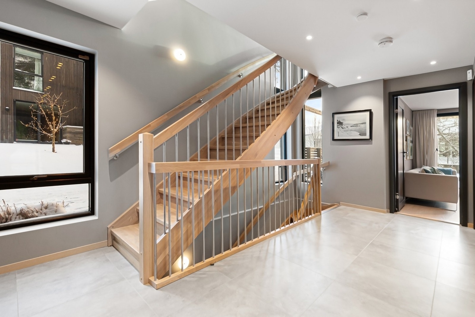 Eiketrapp med lukkede trinn og rekkverk på begge sider leder videre opp i etasjene og understreker boligens gjennomførte uttrykk. Galleribilde