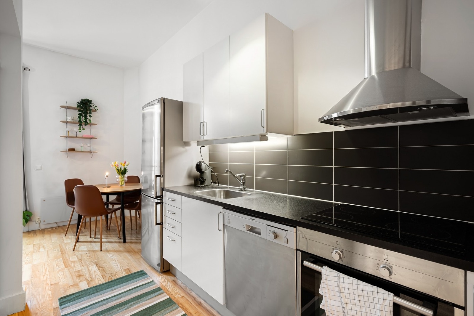 Kjøkkenet er fra 2010 er en praktisk designet åpen løsning tilknyttet både stuen og entré. Innredningen har hvite, glatte fronter og en laminert benkeplate med underlimt oppvaskkum. Galleribilde