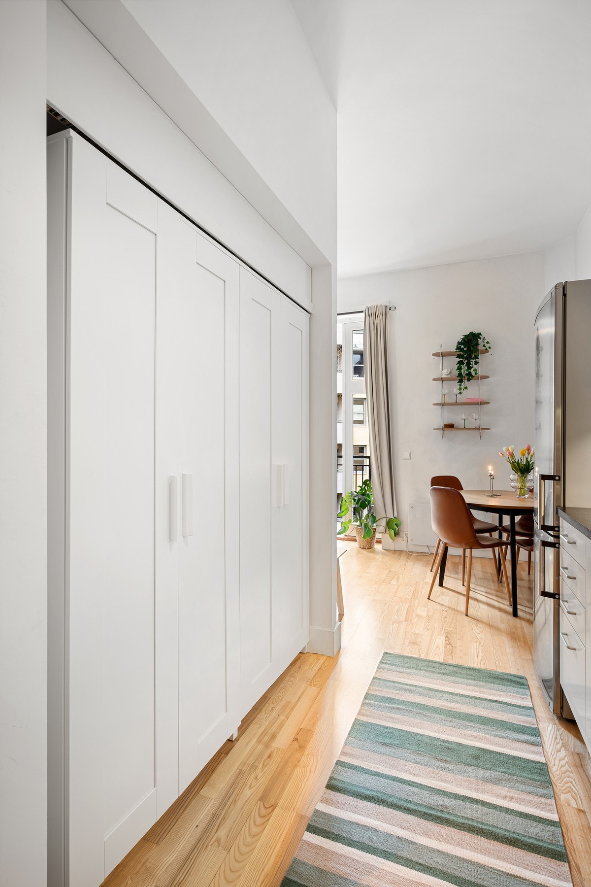 Videre har rommet en åpen garderobeløsning og fastmontert stige ved den ene veggen som gir tilgang til en smart lagringshems. Galleribilde