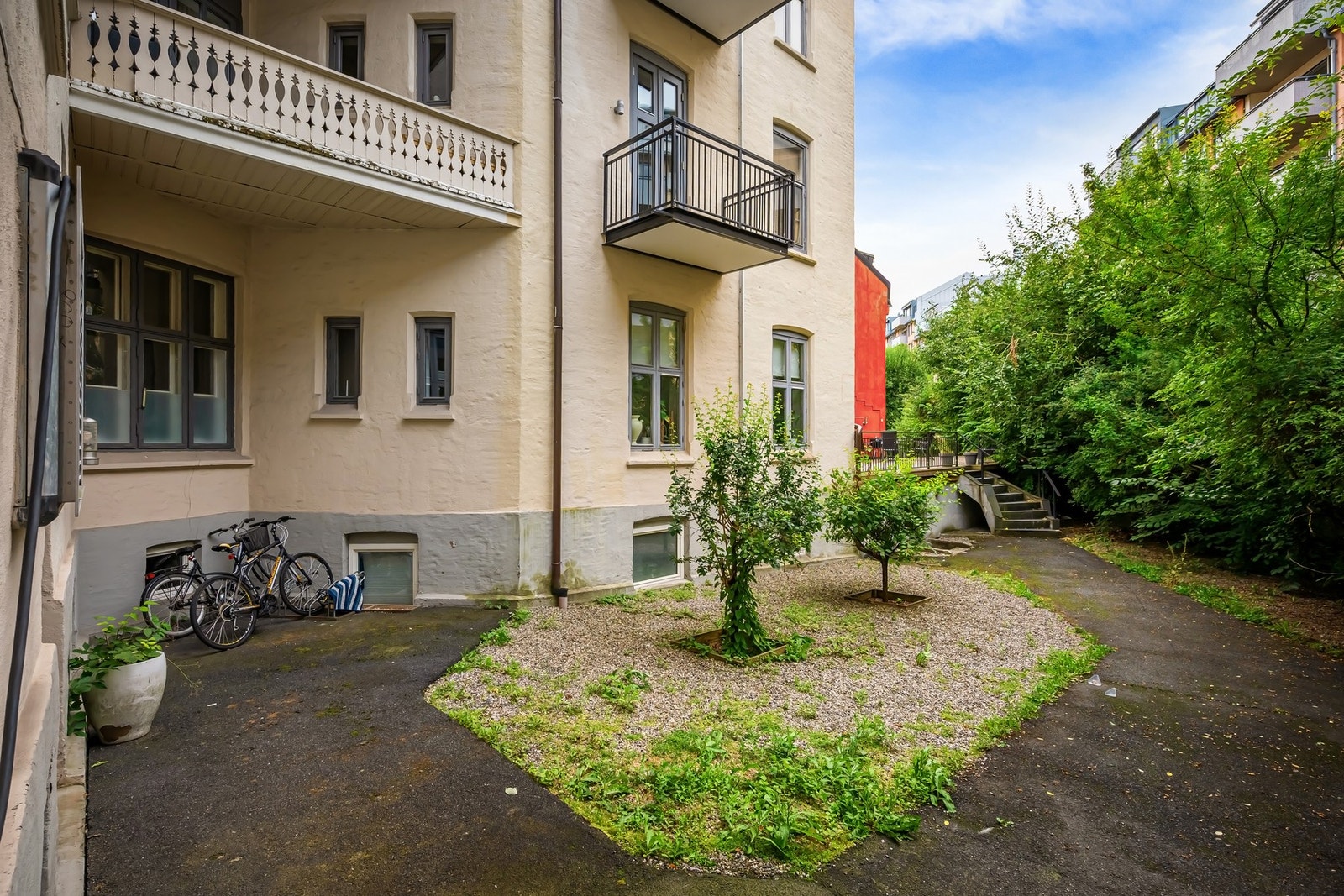 Representativ bakgård som er pent opparbeidet med internveier, prydbusker og blomster. Galleribilde