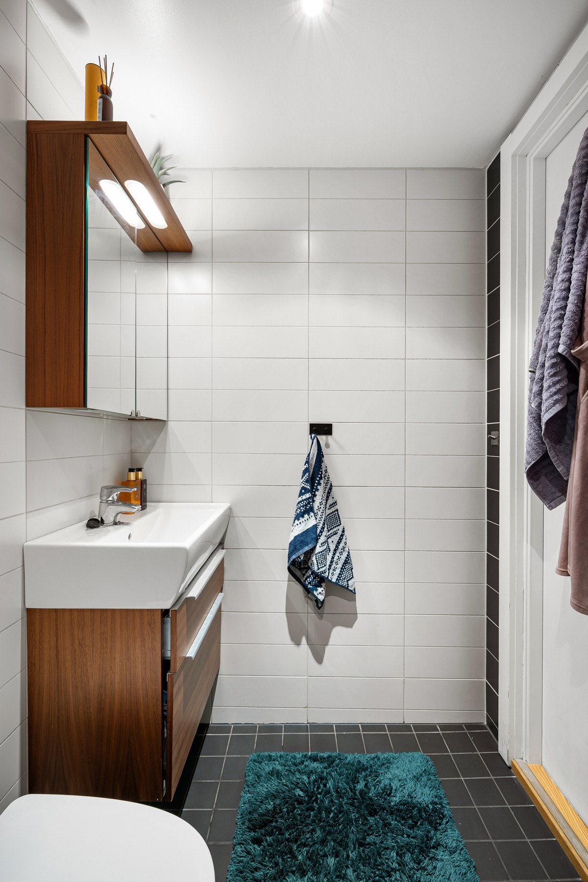 Videre er rommet utstyrt med veggmontert toalett og dusjhjørne med innfellbare glassdører. Galleribilde