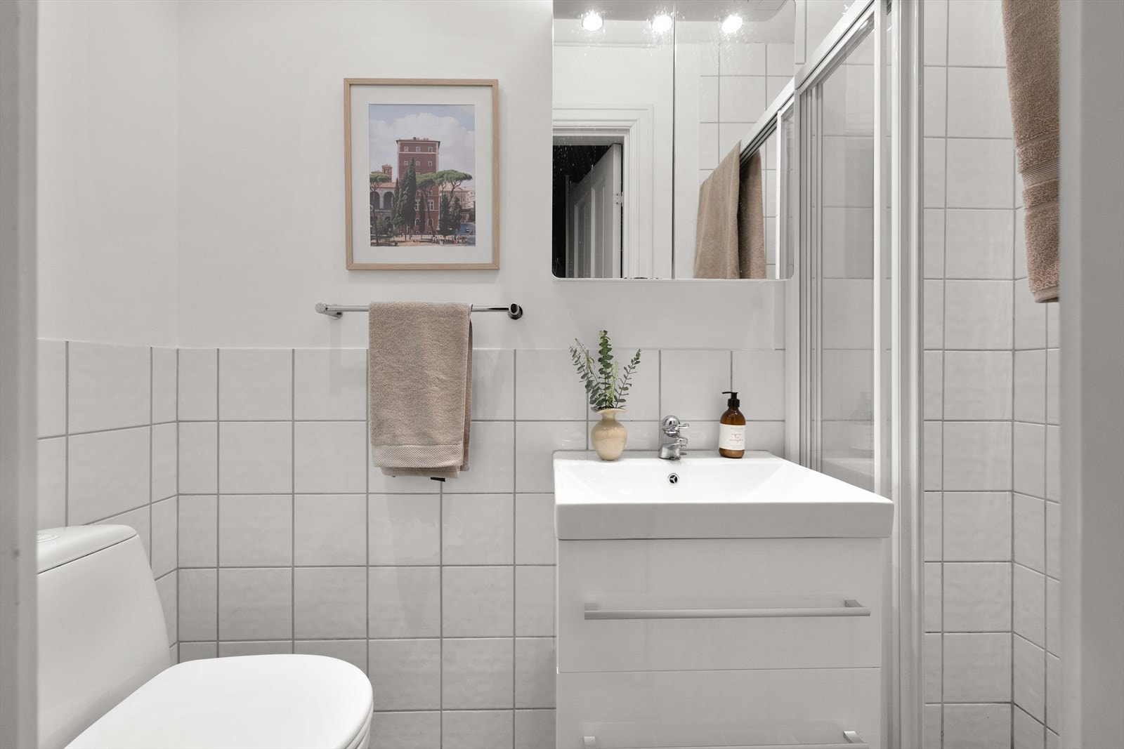 Praktisk bad med elektrisk gulvvarme som gir god komfort. Servant med stilrent ettgreps armatur fra FM Mattsson, samt speilskap med spotter. Galleribilde