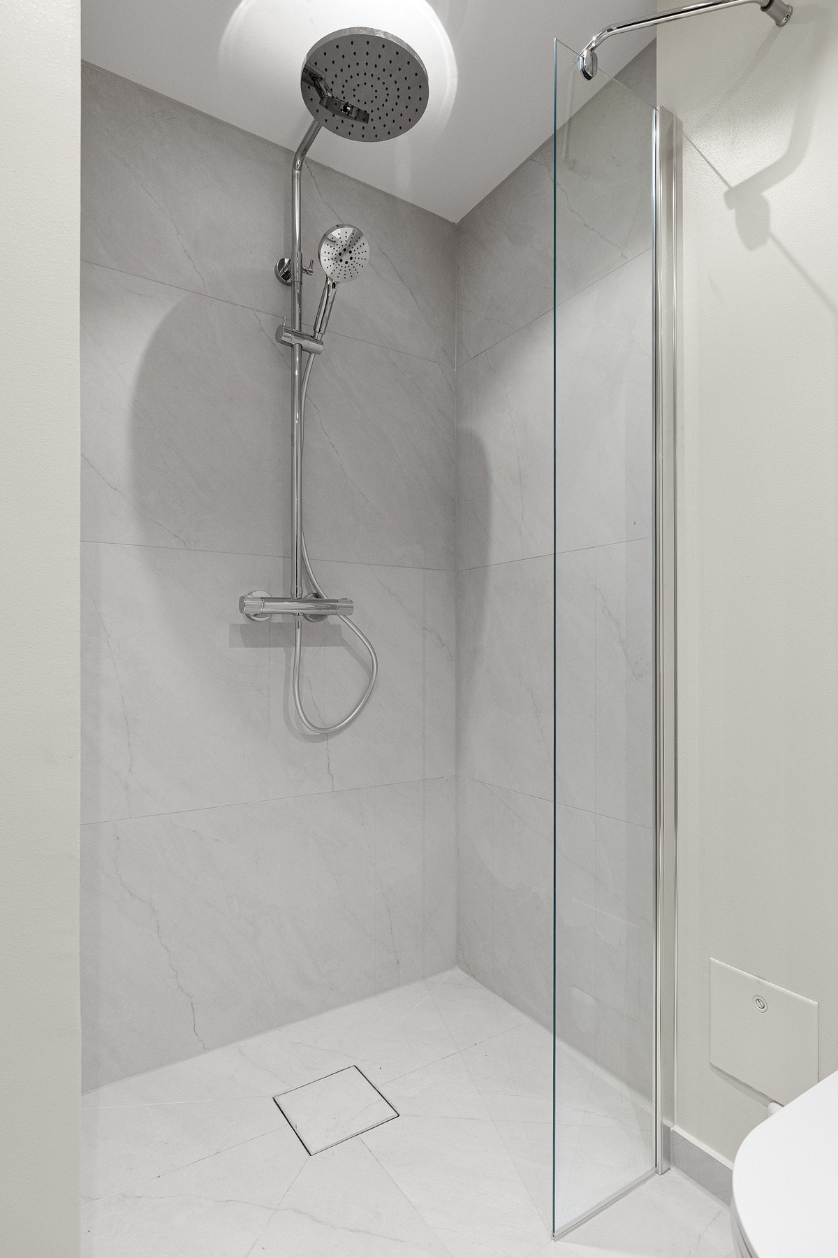 Både waterfall- og hånddusj - alt nytt i 2025. Tile insert sluk i samme flis som gulvet. Galleribilde