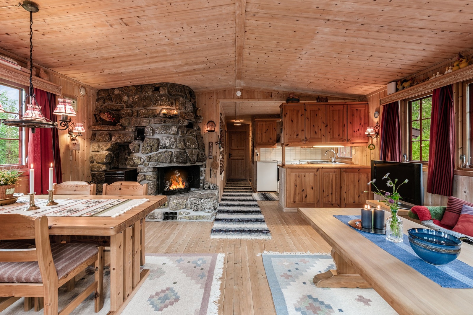 Koselig hytte med peis, åpen stue- og kjøkkenløsning. Galleribilde