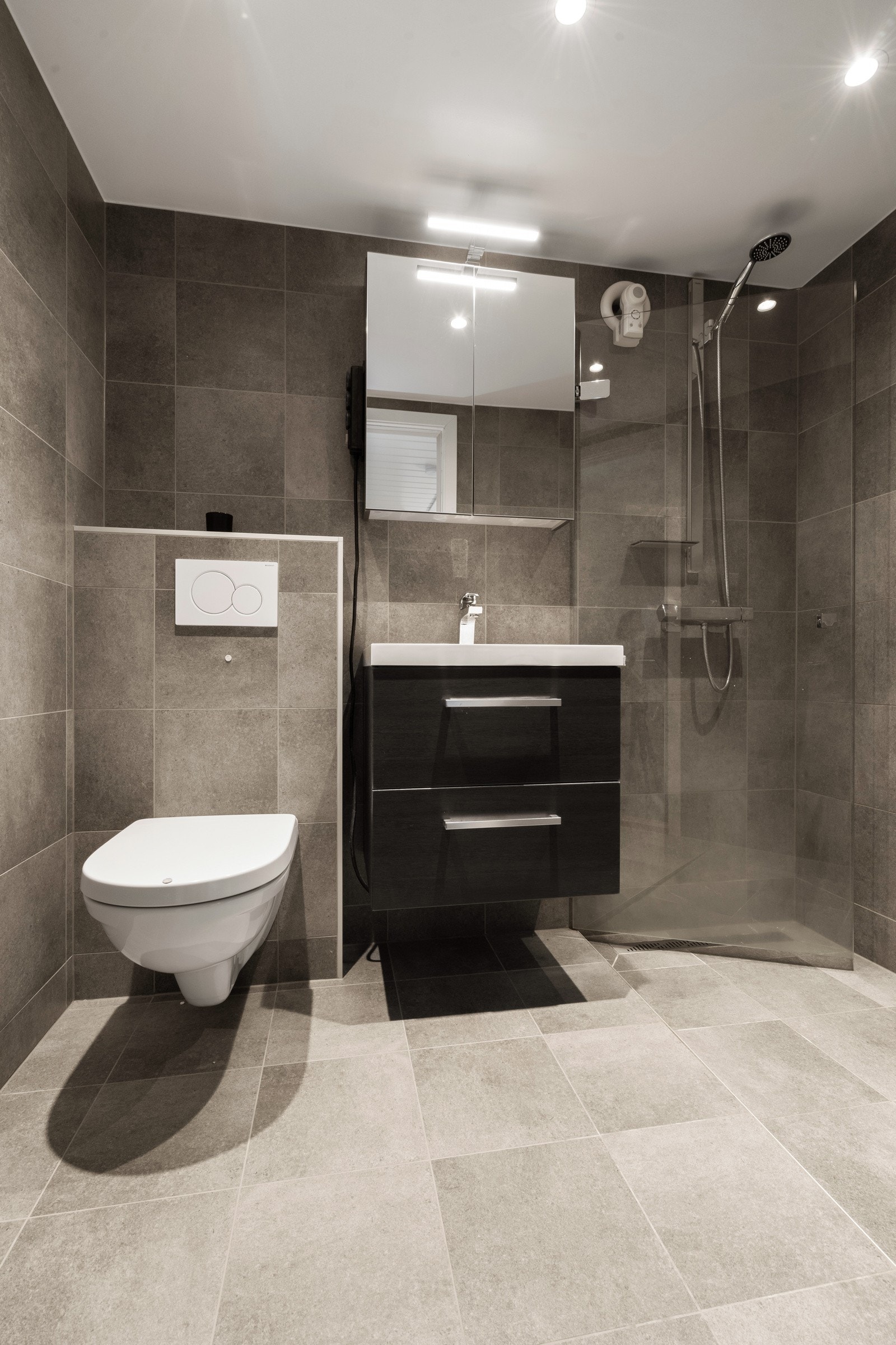 Badet ble oppgradert av fagfolk i 2021 og fremstår stilrent og tidsriktig med behagelig gulvvarme. Galleribilde