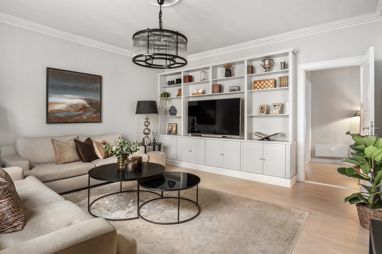 Plassbygde hylleløsninger, eikeparkett i gulv og delikate farger på veggflatene. Galleribilde