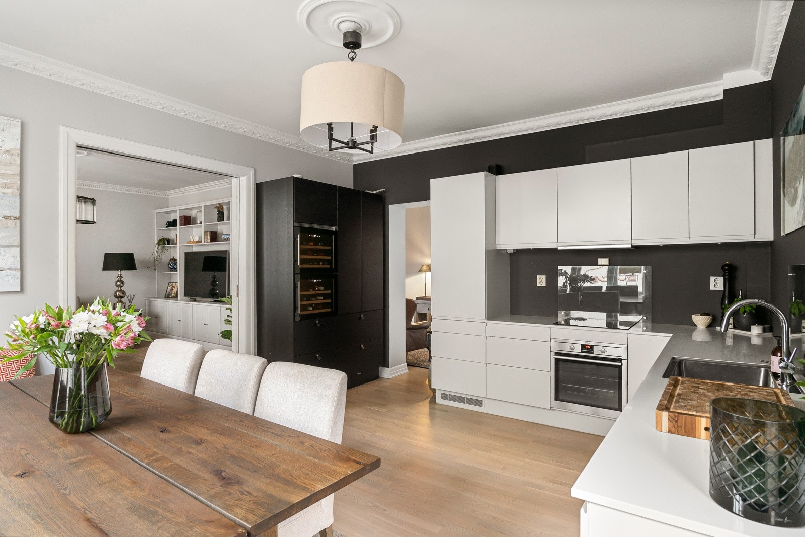 Innredning med glatte, folierte fronter. Corian benkeplate med planlimt kum i rustfritt stål. Belysning via downlights under overskap. Galleribilde