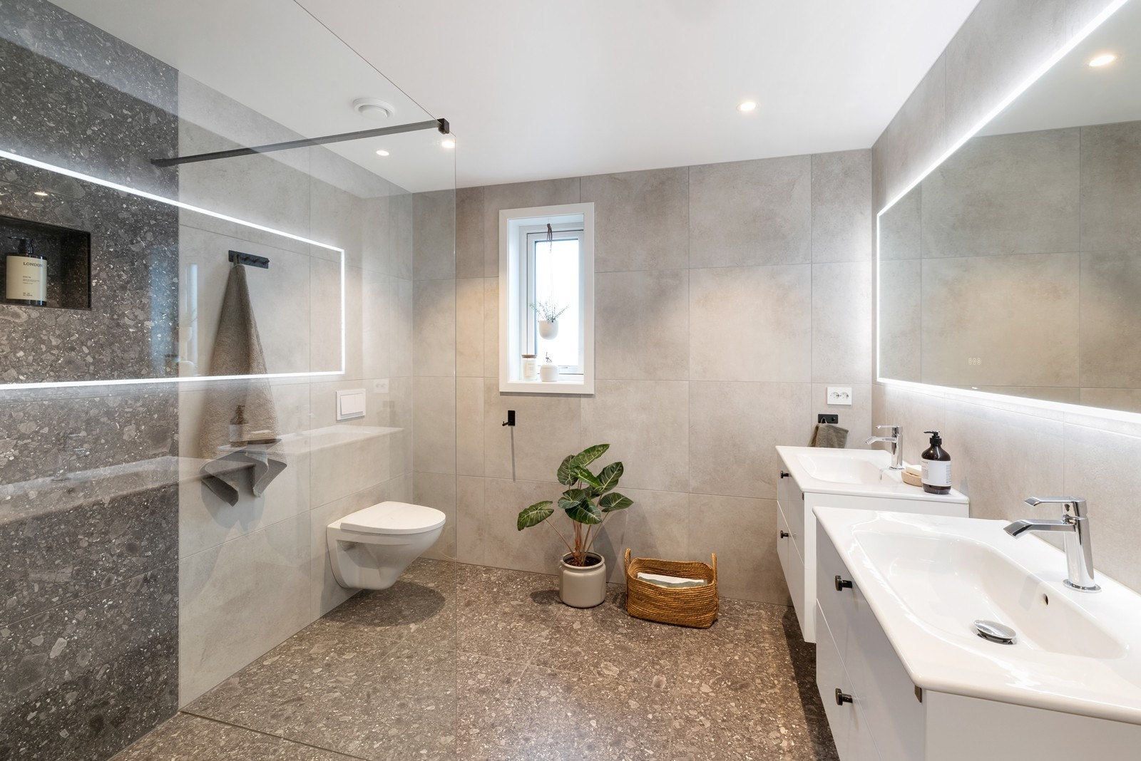 I underetasjen er det videre et lekkert flislagt baderom med varme i gulv. På badet er det servant med oppbevaring, vegghengt toalett, og dushjørne med regnfalssdusj. Galleribilde