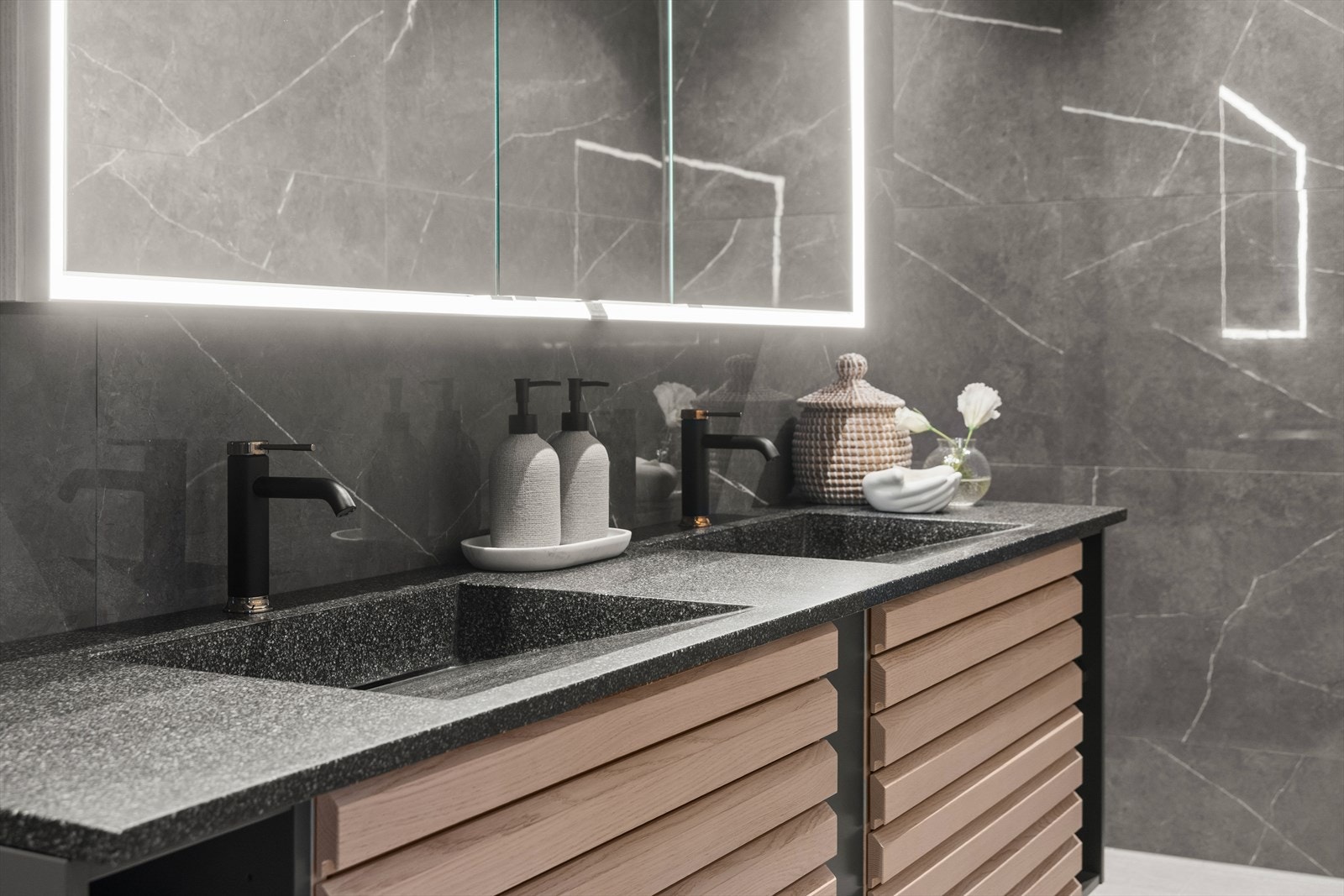 Badet er utstyrt med dobbel servant med underskap, speilskap med lys, toalett og dusjnisje med regndusj Galleribilde