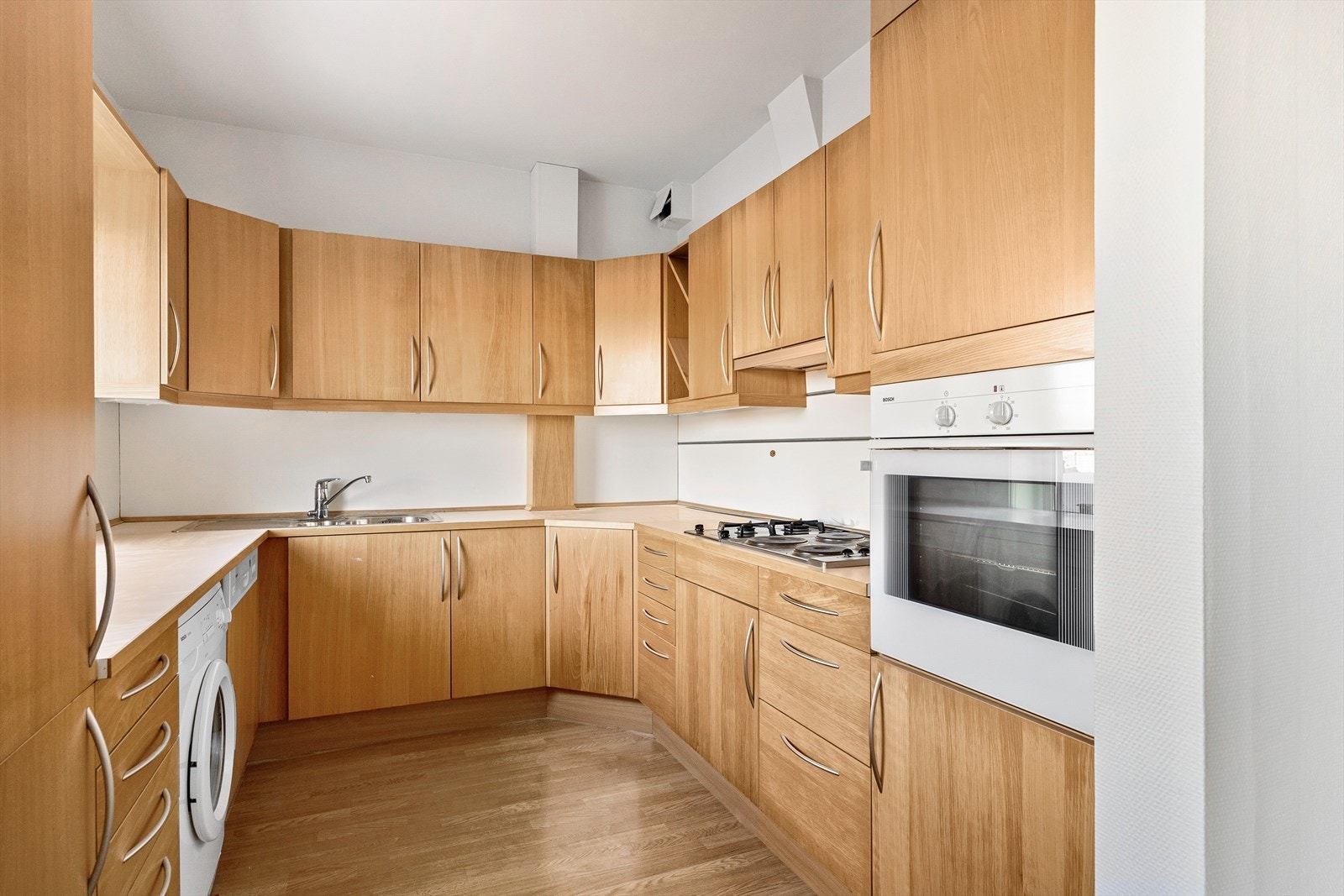 Kjøkkenet er utstyrt med laminatbenkeplate med nedfelt vaskekum i børstet stål og ettgreps krummet armatur fra Grohe. Galleribilde