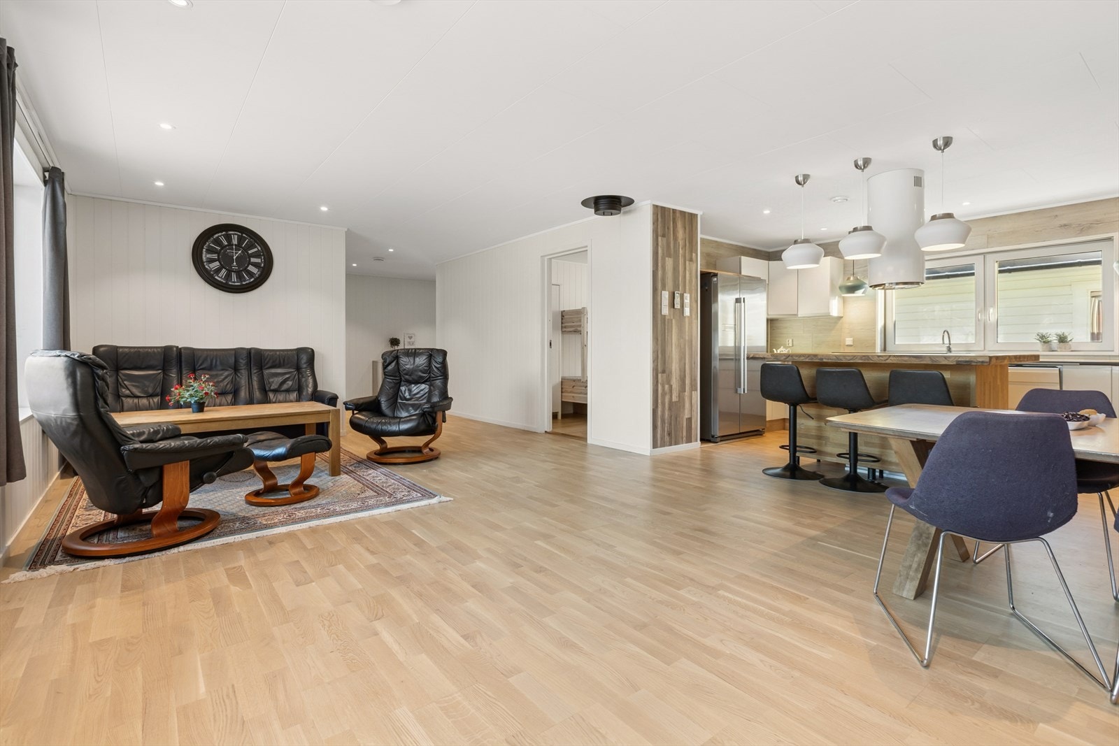 Den åpne løsningen mellom stue og kjøkken gir et sosialt og romslig oppholdsrom. Galleribilde