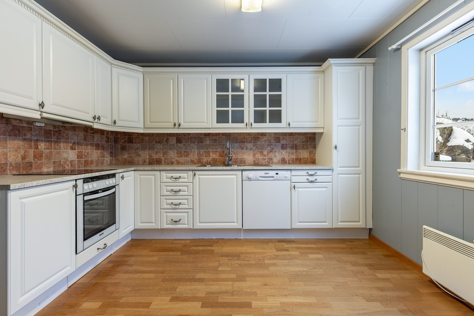 Integrerte hvitevarer på kjøkken. Platetopp, komfyr samt oppvaskmaskin Galleribilde